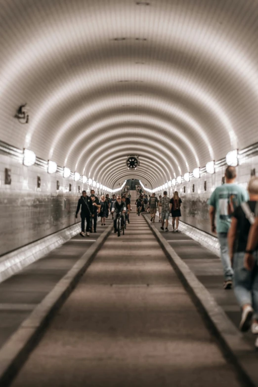 people walking down the hallway in a large tunnel