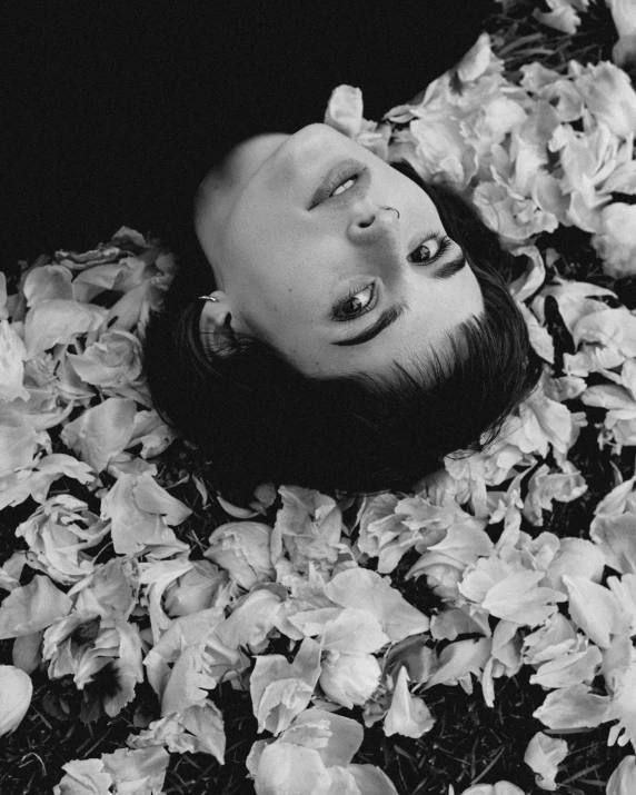 a woman laying in a pile of flowers