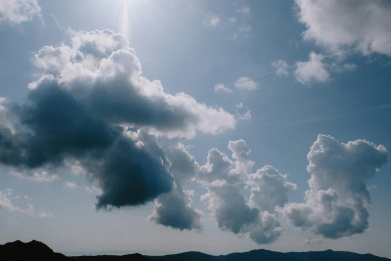 the sun shining through clouds over a field