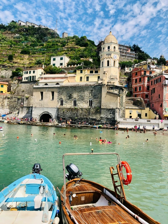 several boats anchored at the waters edge in a city