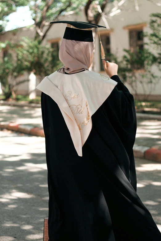 a woman wearing a graduation robe talking on a phone