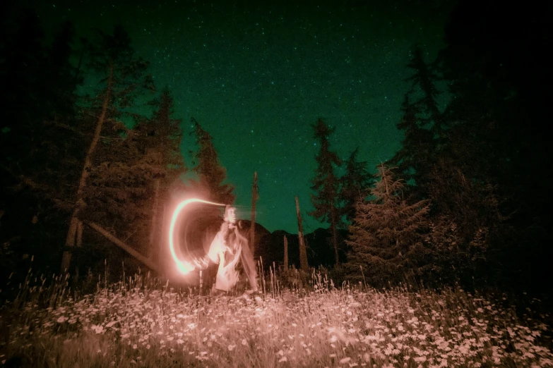 a person holding a glowing disc in a forest