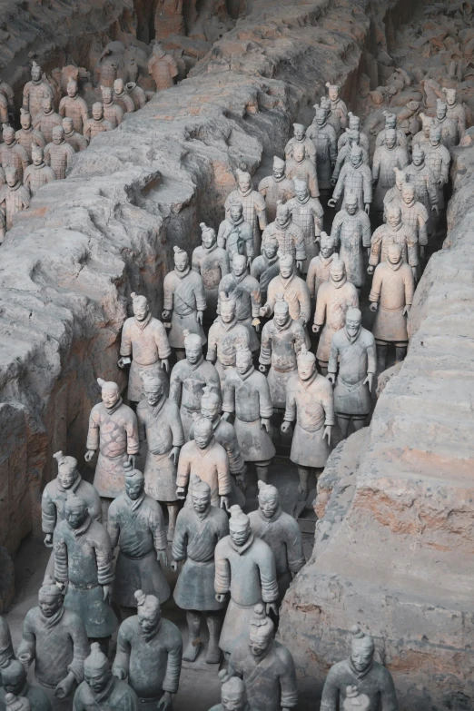 a group of small asian figurines in an archeological setting