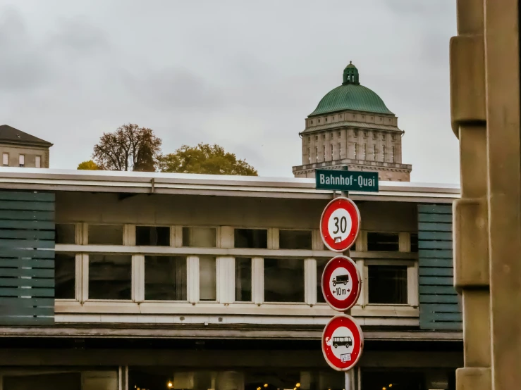 several round street signs next to a tall building