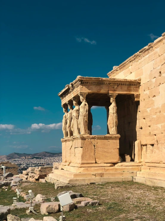 some type of ancient building with statues at the top