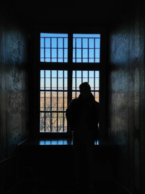 the light in the room shows a person standing in front of a window