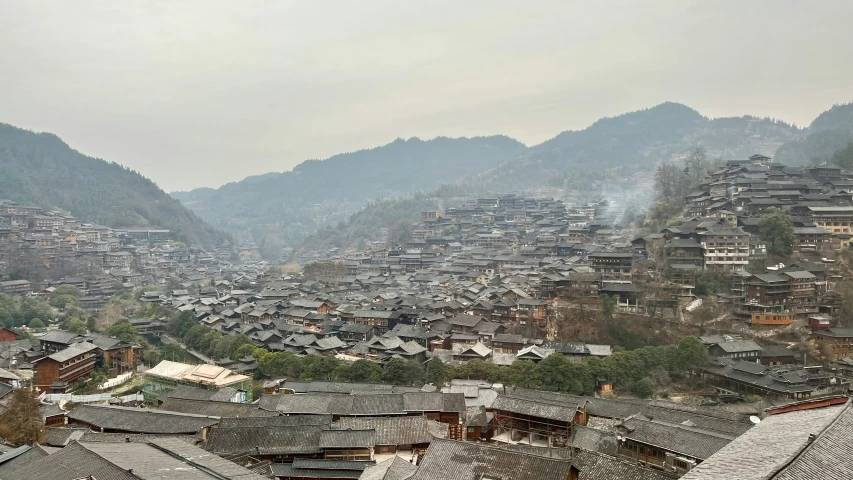 a village nestled in the mountains next to some hills