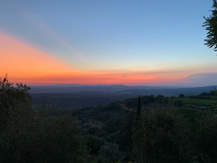 a colorful sky is seen over a mountainous landscape