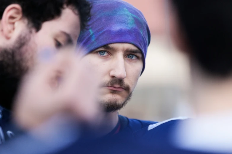 a young man in a purple hat wearing a blue headband