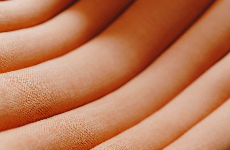 an up close view of orange fabric with many folds