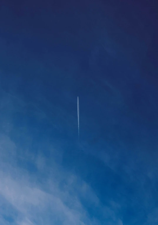 a jetliner flying through a cloudy blue sky