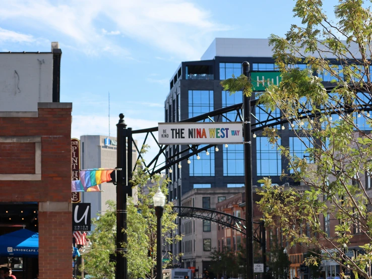 the corner of a street that is under tall buildings