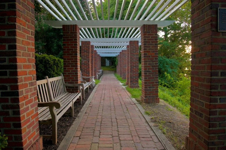 the wooden benches are all along this brick pathway