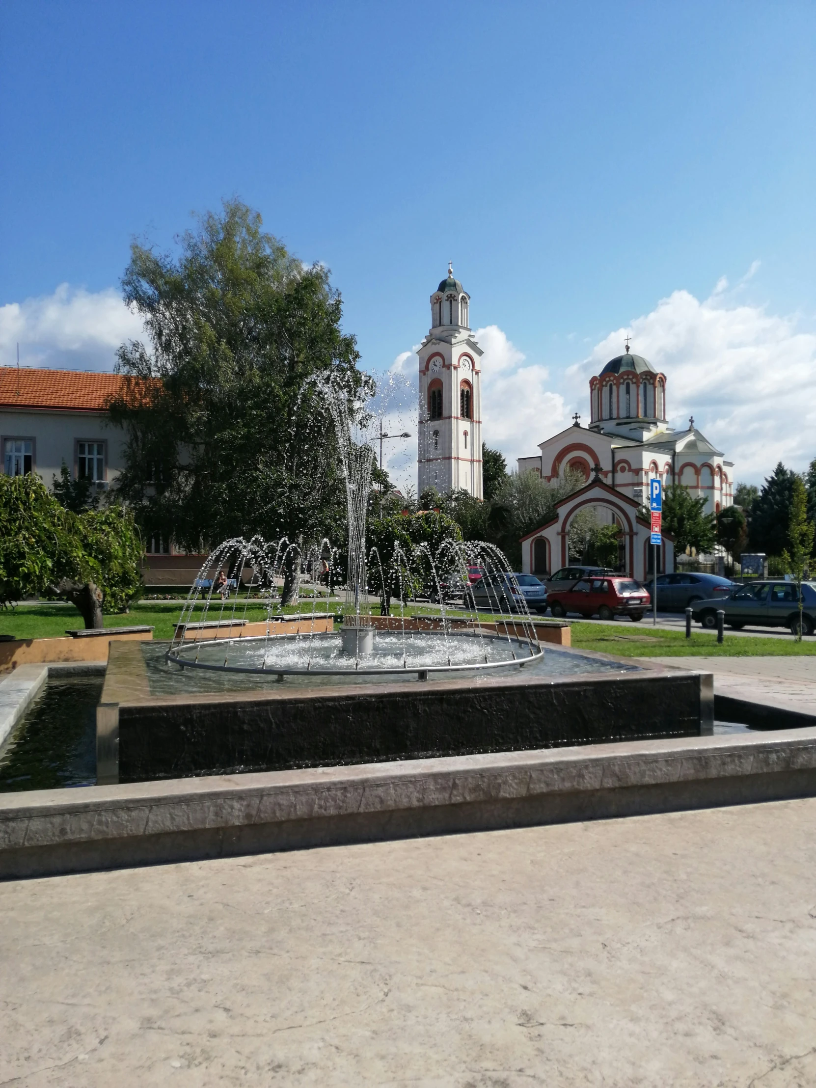 a fountain with a clock tower in the background