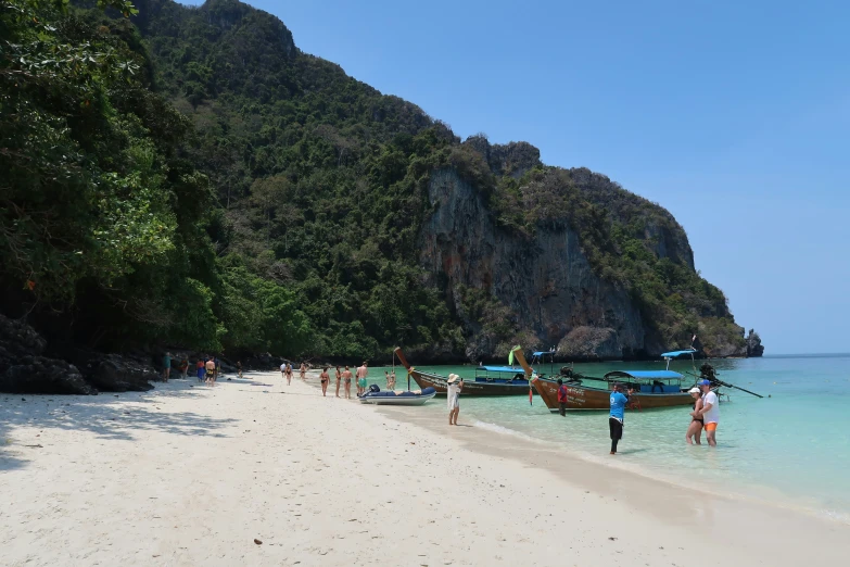 boats lined up on the beach near some people