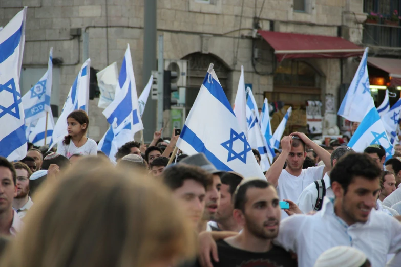 a bunch of people are standing near flags