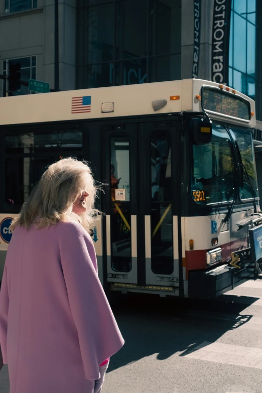 a women walking toward a bus at a city street