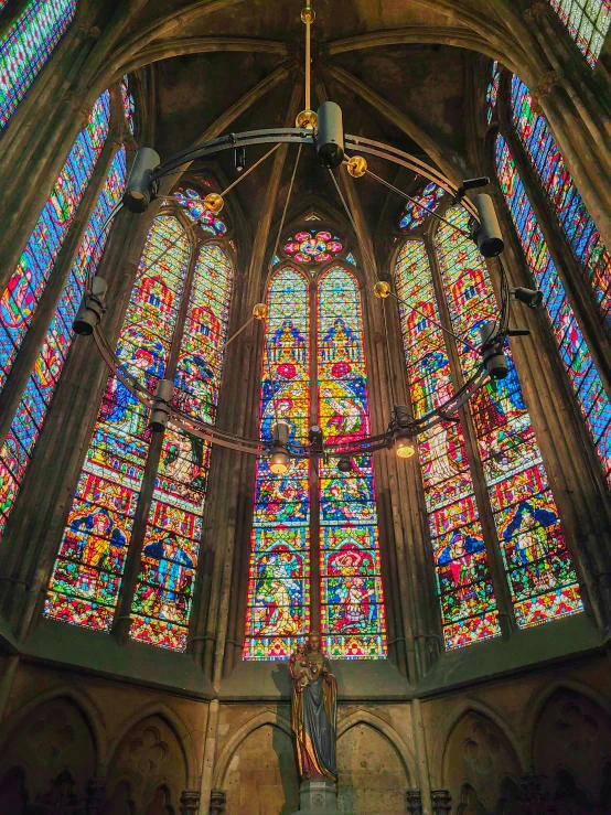 an elaborate, large window in a cathedral is shining bright