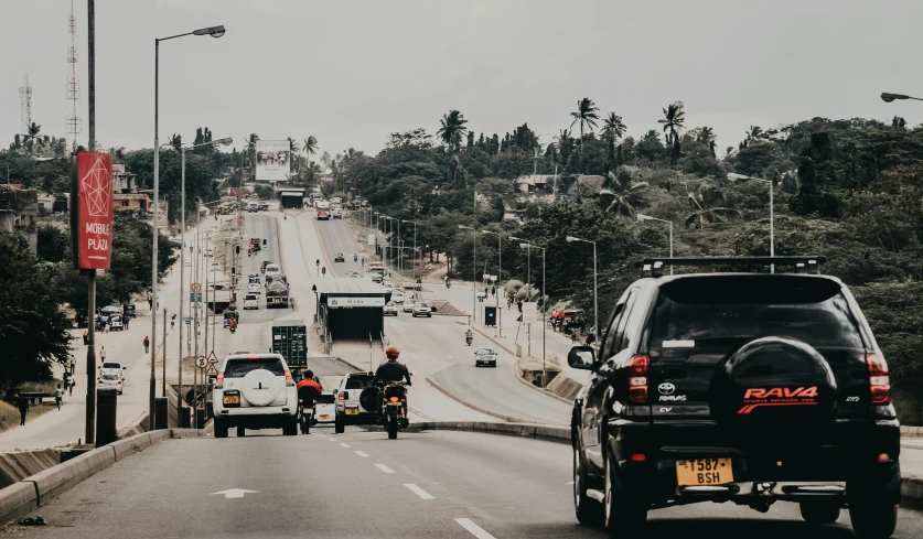 a couple vehicles are on a road with many other traffic