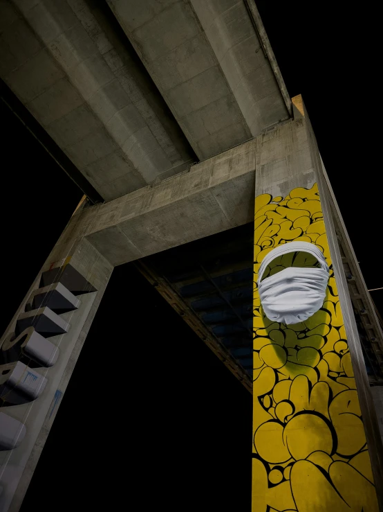 a yellow skateboard sitting underneath a bridge at night