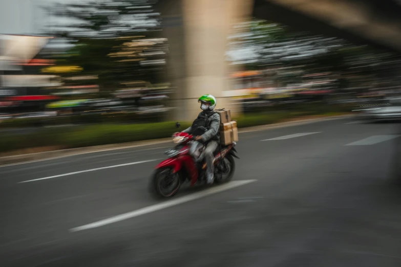 a man riding down the street on his red motorcycle