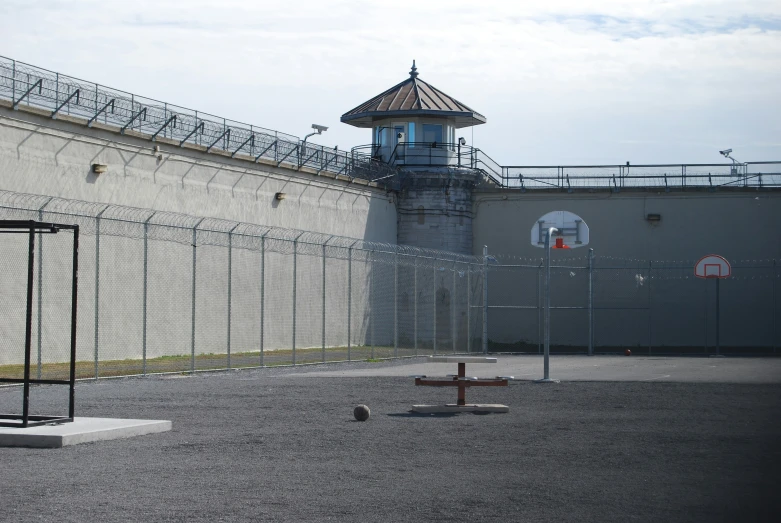 a building with an antenna and a chain link fence