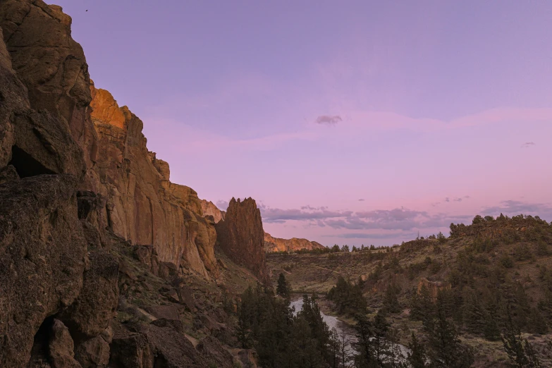 the sky is purple over the rocky terrain