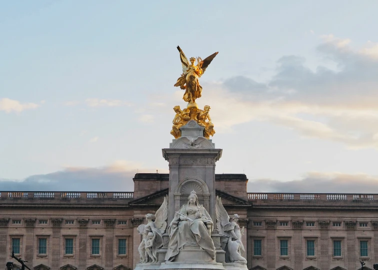 the statue is in front of a building that has many windows