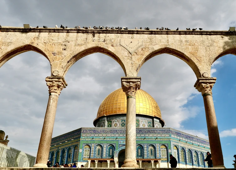 dome with blue tiles and yellow domes near two columns