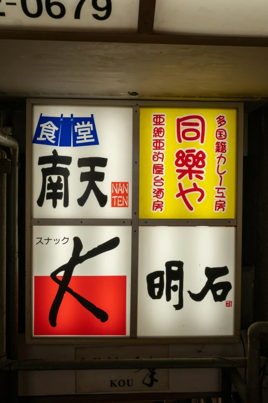 asian street signs displayed against the wall of a train station