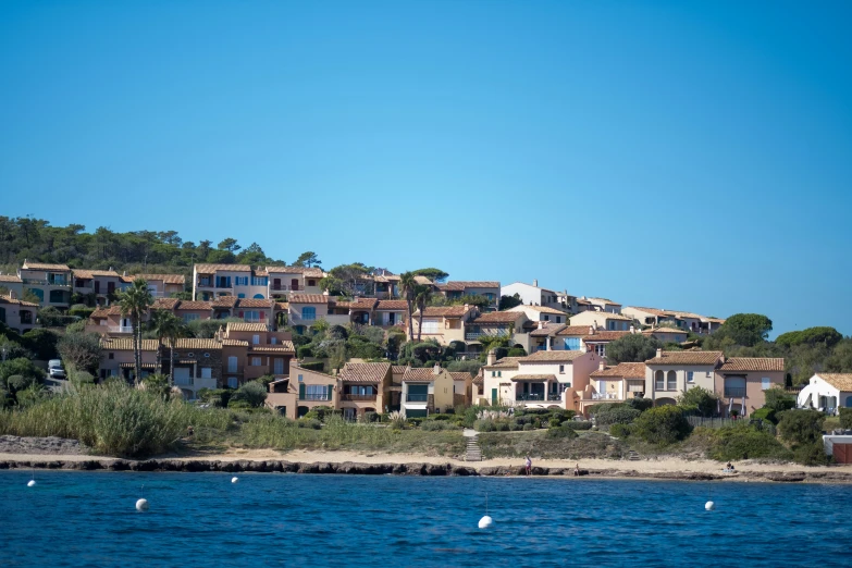 a mountain side house with a beach in the background