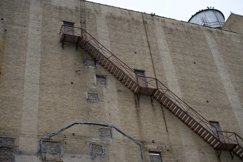 an old building that has fire escape ladders going up the side
