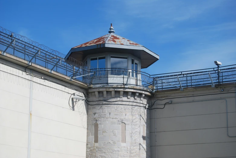 an old stone building has a turret and railing on the roof