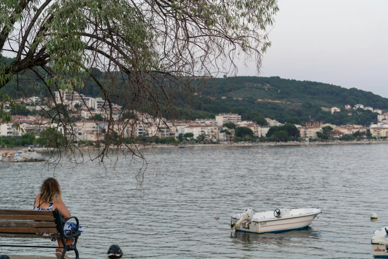 a boat floating on the water with a person sitting at a bench