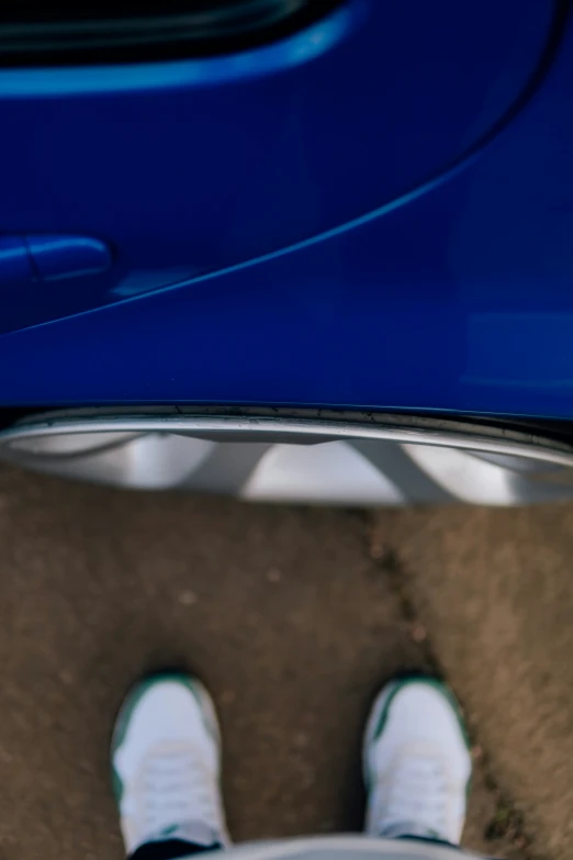 shoes are placed next to a blue car