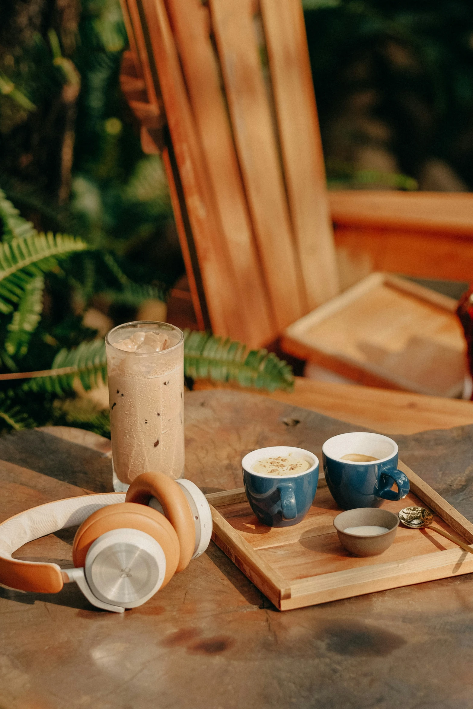 a table with cups of coffee, headphones and a tray on it