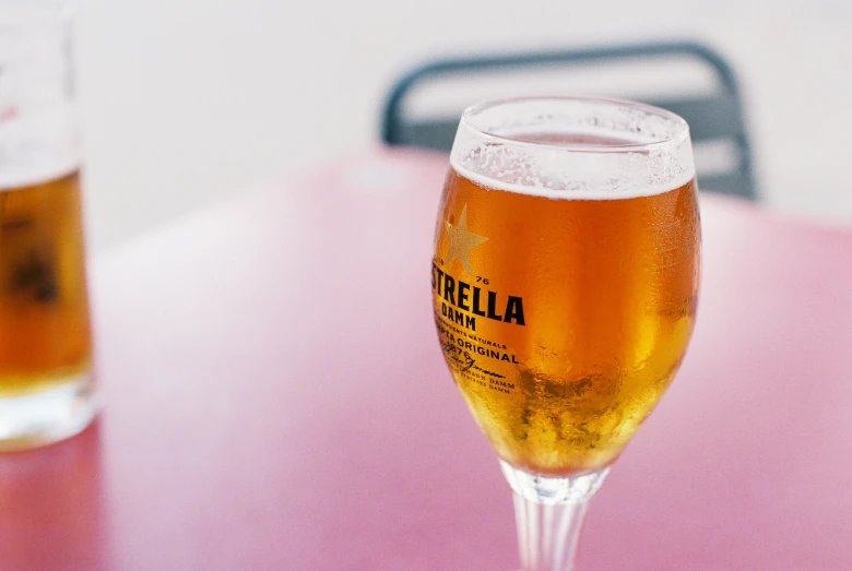 a glass of beer next to a bottle on a table