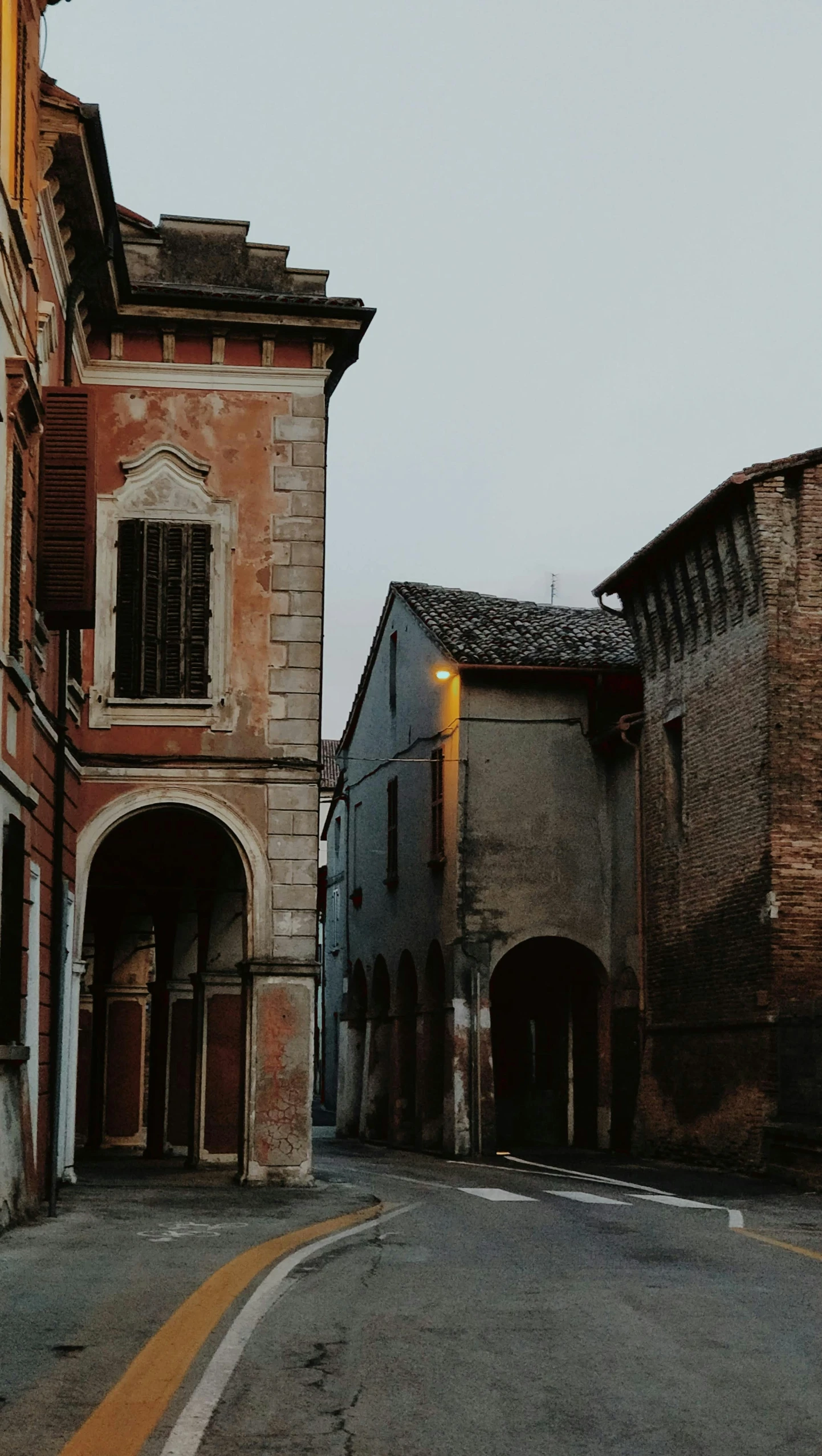 an old street with one building with a clock on the top of it