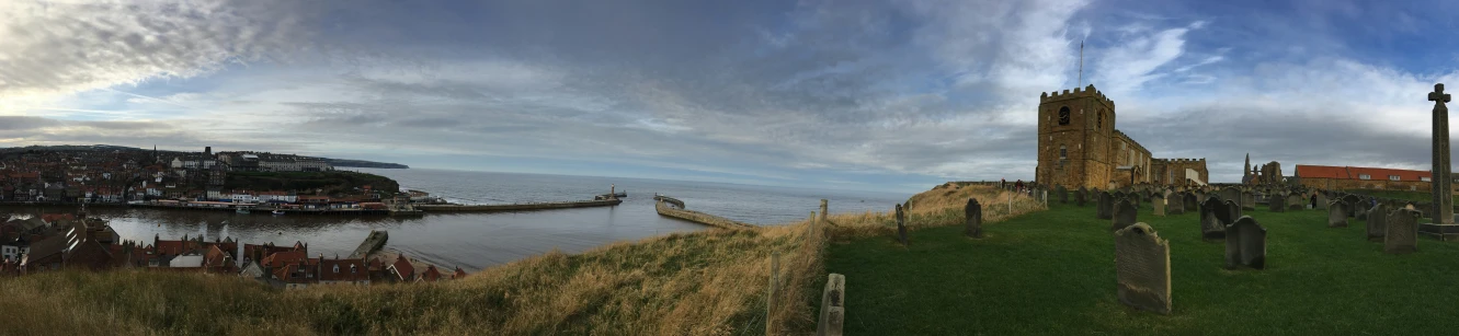 a castle overlooks a body of water and an old cemetery