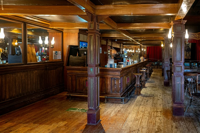 a bar with a few tables, chairs and bottles