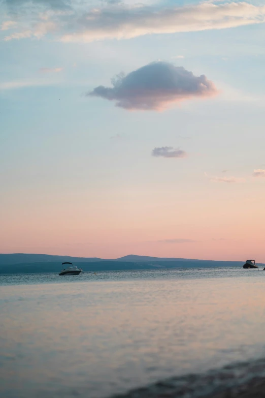 the view of a few boats in the distance with a cloud over them