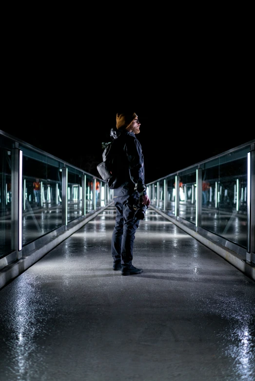 a man is standing in an illuminated tunnel looking up at the sky