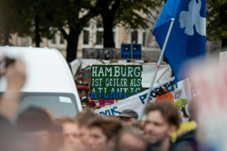 a bunch of people holding signs, one of them is pointing to soing