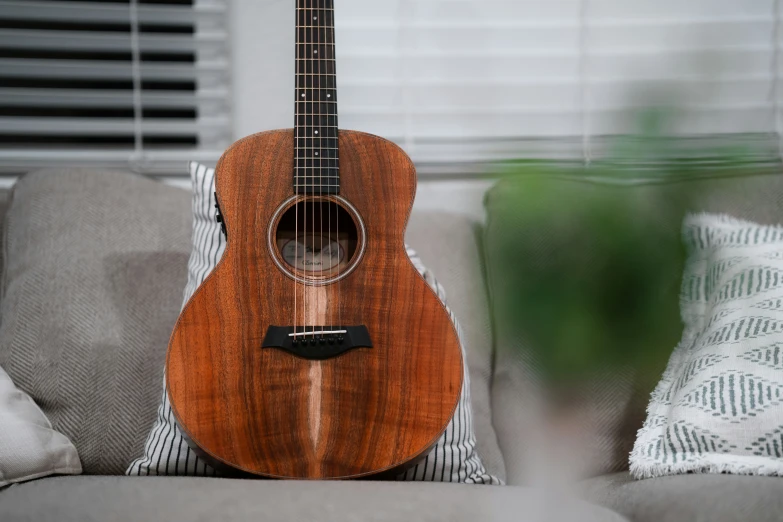 a close up of an acoustic guitar on a couch