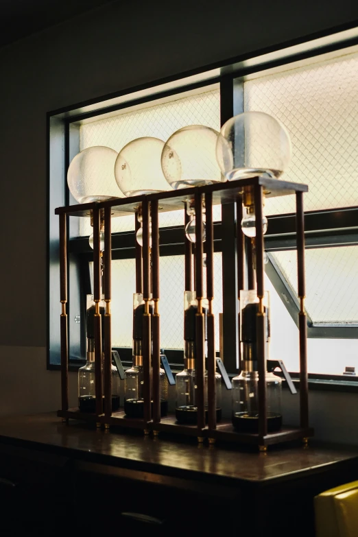 several lights sit atop a wooden table in front of a window