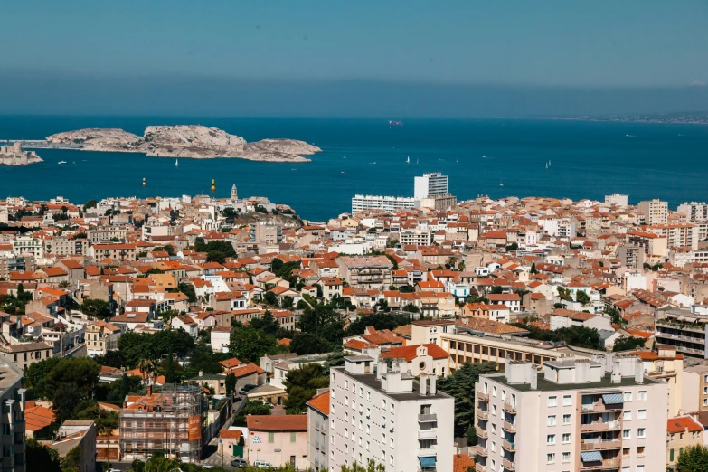 a city with lots of red roofs near the ocean