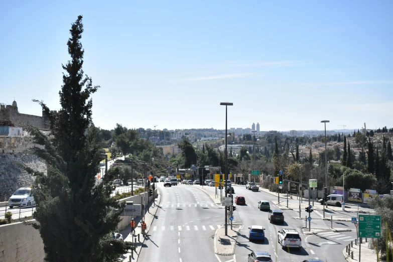 cars are going down the street in an area with large hills