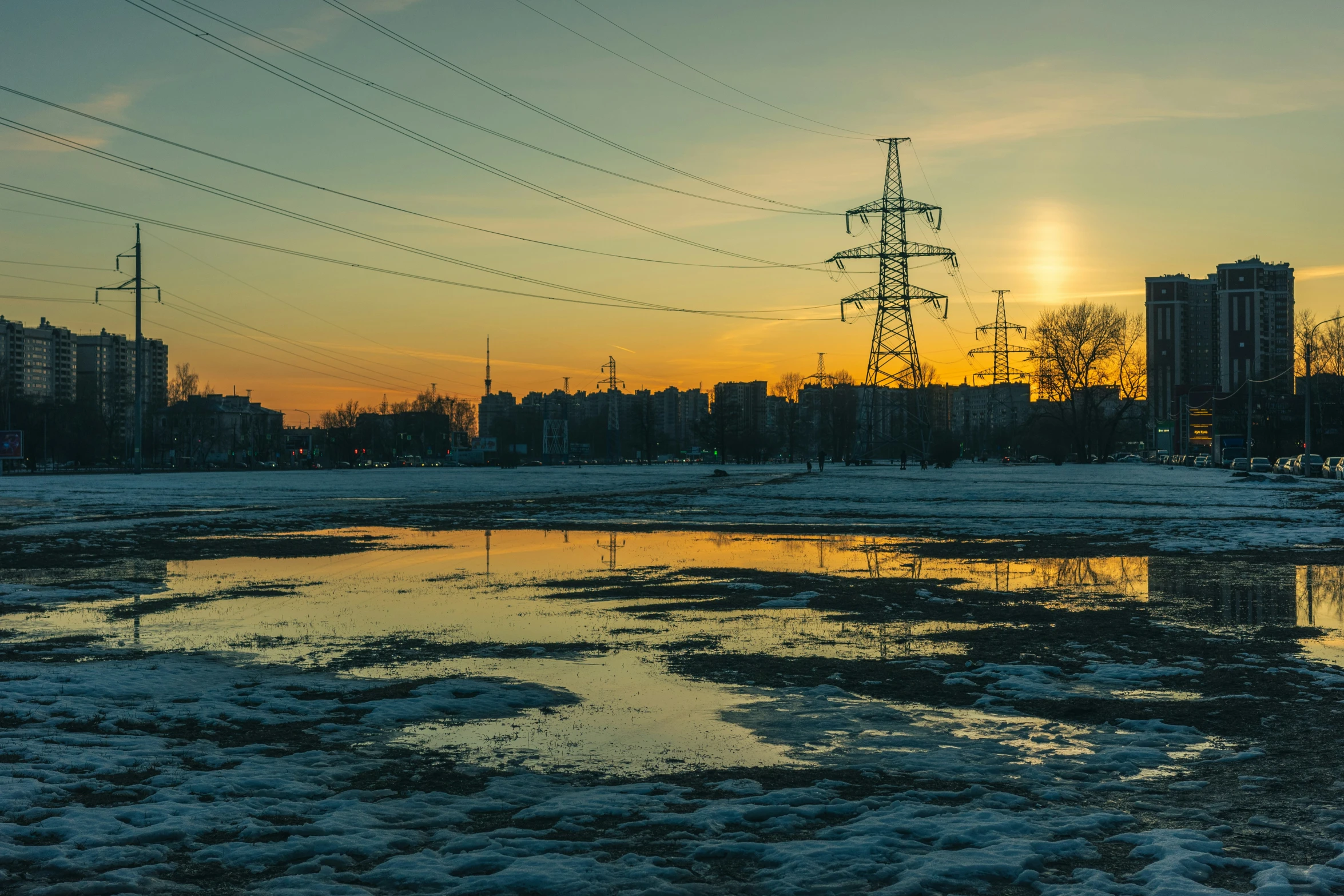 a sun setting with the sun shining above buildings