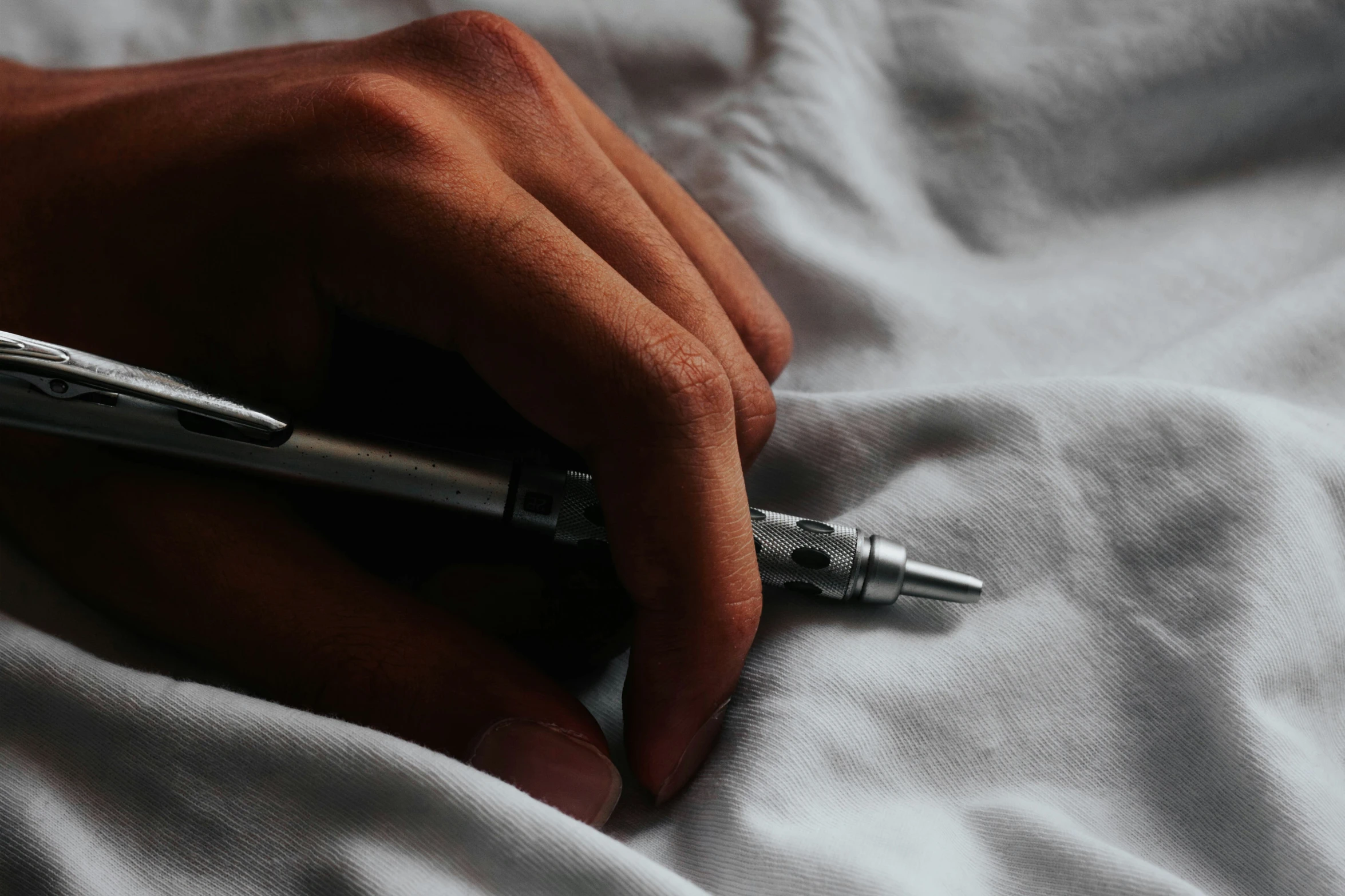 a close up of a persons hand writing on paper