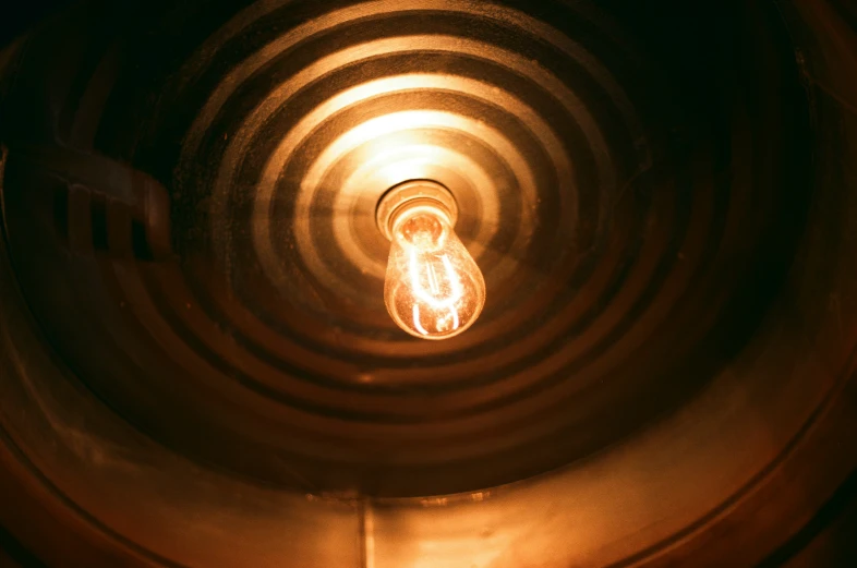 an illuminated bulb sitting in the center of a circular spiral pattern
